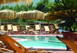 a group of chairs and umbrellas next to a swimming pool at Montespina Park Hotel in Naples