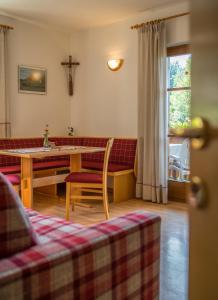 een woonkamer met een tafel en een kruis aan de muur bij Villa Tannenheim in Castelrotto