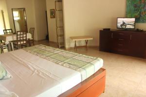a bedroom with a bed and a table and a dining room at Casa Del Sol in Lo de Marcos