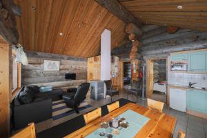 una sala de estar con una mesa en una cabaña de madera en Osman Kelohovi en Utsjoki