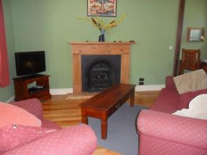 a living room with a fireplace and a coffee table at Tramway Cottage in Strahan
