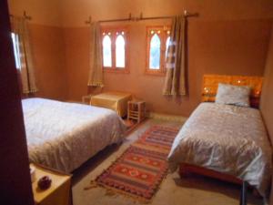 Rúm í herbergi á Hotel Carrefour des Nomades