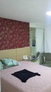 een slaapkamer met een bed met een zwart shirt erop bij Apartamento em Golf Ville Resort in Aquiraz
