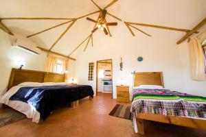 a bedroom with two beds and a ceiling fan at Palapas Ventana in La Ventana +74 photos