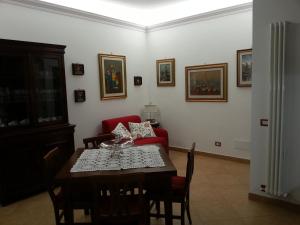 a dining room with a table and a red couch at CHEZ-ROBY in Rome