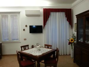 a dining room with a table with chairs and a television at CHEZ-ROBY in Rome