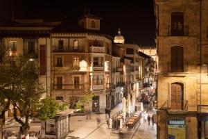 Una calle de la ciudad por la noche con gente caminando por la calle en Apartamentos Boutique Salamanca, en Salamanca