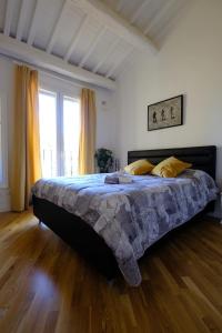 un grande letto in una camera da letto con pavimento in legno di Rodolfo Suite a Firenze