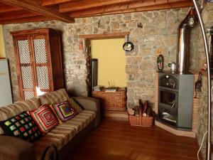 a living room with a couch and a stone fireplace at El Requexu de Cervera in Cervera