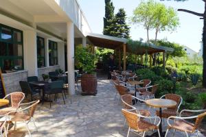 - une rangée de tables et de chaises sur la terrasse dans l'établissement Kleine Hexe B&B Pension, à Pirovac