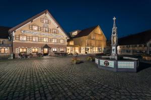 a large building with a clock tower in a courtyard at Ellgass Allgäu Hotel in Eglofs