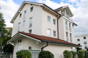 a white building with a red roof at Boutique Hotel Beckenlehner in Unterhaching +46 photos