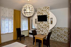 巴特洪堡的住宿－市中漫步酒店，客厅配有桌椅和吊灯。