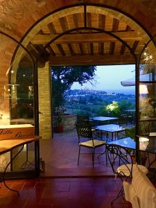 patio ze stołami i krzesłami oraz widokiem w obiekcie B&B Countryhouse Villa Baciolo w mieście San Gimignano