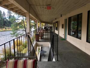 a porch of a building with chairs and a river at River's Edge Lodge in Leavenworth