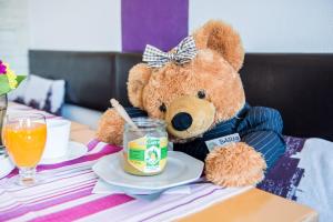 ein Teddybär auf einem Tisch mit einem Teller Essen in der Unterkunft Hotel Burgblick in Thallichtenberg