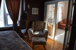 a bedroom with a chair and a mirror at Sir Edgar House B&B in Dauphin