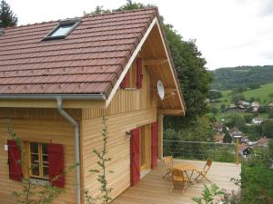 een huis met rode deuren en een terras met een tafel bij Giteovosges in La Croix-aux-Mines