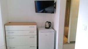 a tv hanging on a wall next to a dresser at Guest House Marija in Sumartin