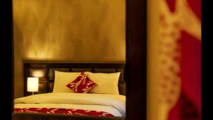 una camera da letto con un letto con cuscini rossi e bianchi di Shams Alweibdeh Hotel Apartments ad Amman