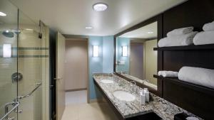 
a bathroom with a sink, mirror, and bathtub at Aava Whistler Hotel in Whistler
