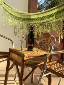 una botella de vino sentada en una mesa con dos copas en Pousada Vivenda da Barra, en Torres
