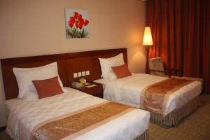 a hotel room with two beds with red flowers on the wall at Super House International in Beijing