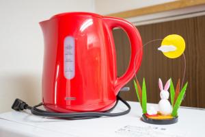 a red appliance sitting on top of a table at Aoi-Riverside Old Townhouse in Kyoto