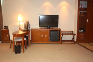 a living room with a tv and a table and a desk at Super House International in Beijing