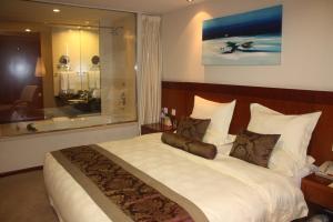 a bedroom with a large bed with white sheets and pillows at Super House International in Beijing