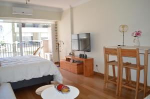 a bedroom with a bed and a tv and a table at Recoleta Deluxe Studio in Buenos Aires