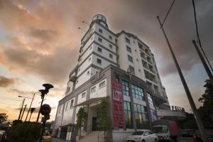 a white building on a street with a cloudy sky at Golden View Serviced Apartments in George Town