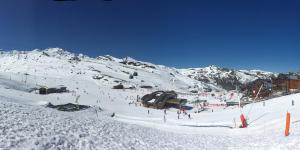 a ski slope with a bunch of people in the snow at Residence Tourotel in Val Thorens