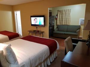 a hotel room with two beds and a flat screen tv at Bayside Inn & Waterfront Suites in Kingston