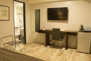 a hotel room with a desk with a television on the wall at 1A Express Hotel in Cagayan de Oro