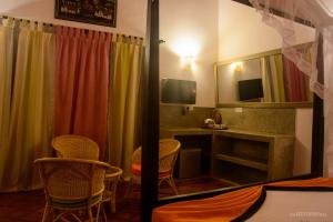 Zimmer mit Stühlen, einem Schreibtisch und einem Spiegel in der Unterkunft Breeze Villa Unawatuna in Galle