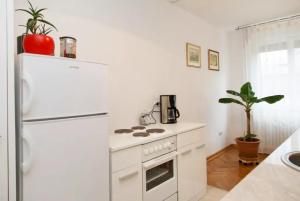 eine Küche mit einem weißen Herd und einem Kühlschrank in der Unterkunft Modern Cozy Apartment in Belgrad