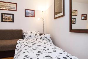 ein Schlafzimmer mit einem Bett und einer Lampe und Bildern an der Wand in der Unterkunft Modern Cozy Apartment in Belgrad