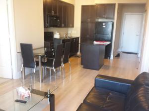a kitchen and living room with a table and chairs at BEST LOCATION/SPECTACULAR VIEW 2 BEDROOMS FURNISHED CONDO S/L RENT in Mississauga