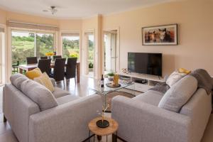 a living room with two couches and a television at Emerald Cottage in Emerald