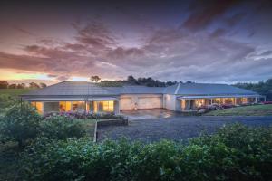 a large white house with a sunset in the background at Emerald Cottage in Emerald