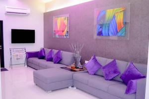 a living room with a couch and purple pillows at Q Bintang Hotel in Alor Setar