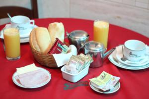 a red table with a basket of bread and two candles at Shelton Hotel in Rio de Janeiro