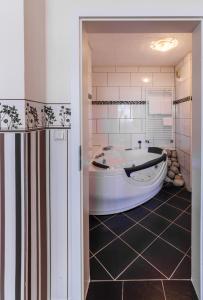 a bathroom with a tub in a room with a tile floor at City Hotel Stolberg in Stolberg