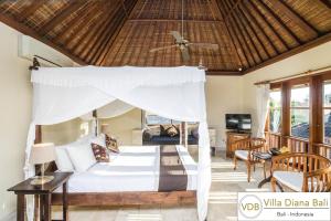 sypialnia z łóżkiem z baldachimem w obiekcie Villa Diana Bali w mieście Legian