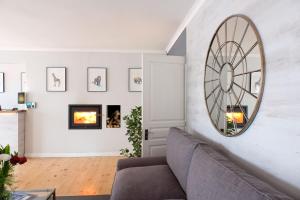a living room with a couch and a mirror on the wall at Vine Guesthouse in Stellenbosch