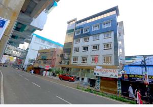a city street with tall buildings and a red car at Kenz Residency in Cochin