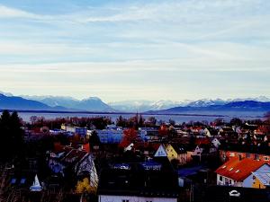 リンダウにあるホテル ガルニ ロイラインの山々を背景とした市街の景色