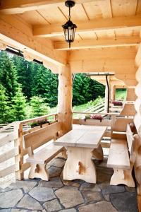 a wooden cabin with a picnic table and benches at Domki pod lasem in Nowe Bystre