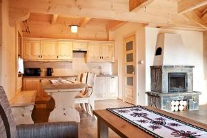 a kitchen with a table and a stove at Domki pod lasem in Nowe Bystre